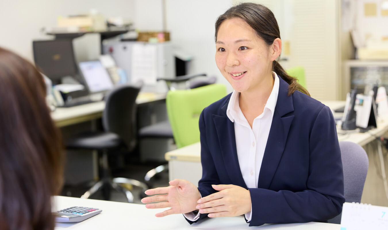 画像：添乗業務も手配業務も担当するスタッフがお客様と笑顔で会話する様子