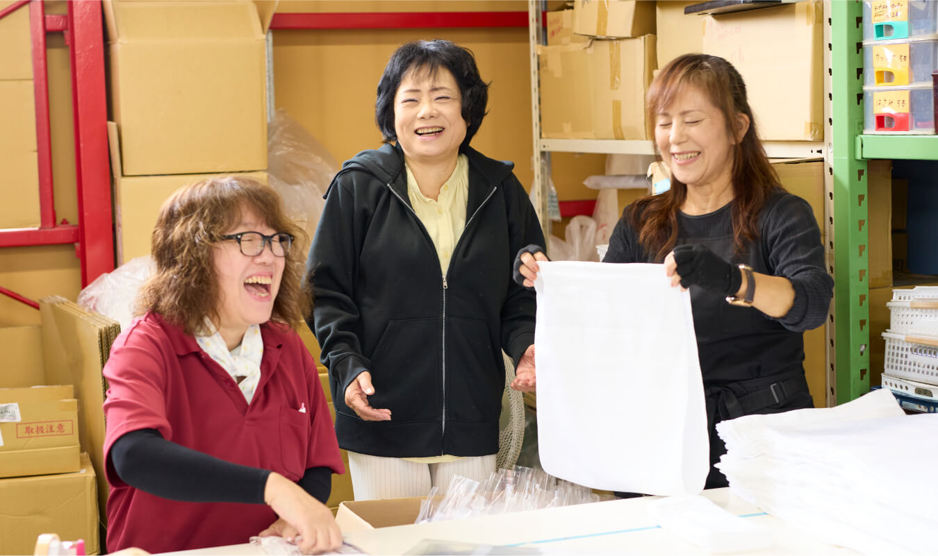 写真：取締役会長とスタッフが笑顔で会話する様子