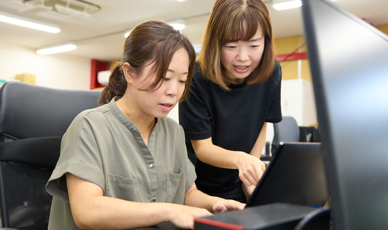 写真：スタッフからスタッフへ仕事を教える姿