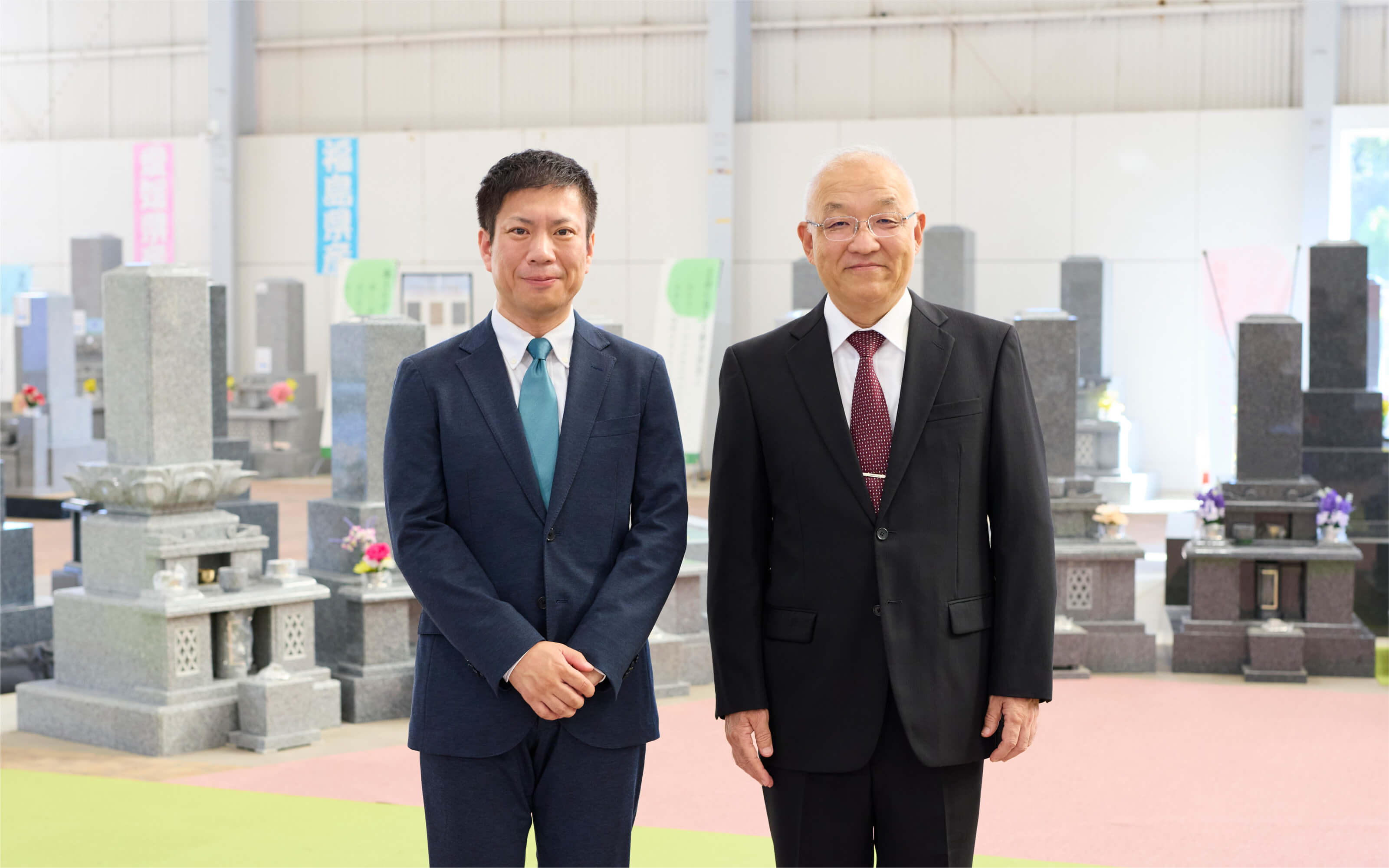 写真：なごやホールディングスの代表取締役社長と中村石材店の顧問が笑顔で並んでいる